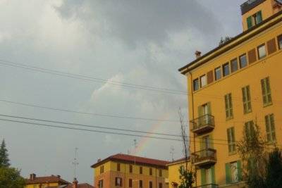 Un arcobaleno spunta tra i palazzi di Bologna