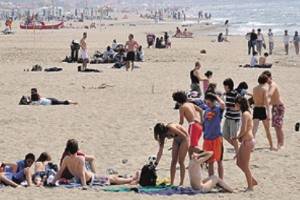 Bagnanti in spiaggia che approfittano del sole estivo.. e non solo