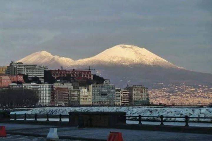 Veduta mozzafiato dalla città di Napoli verso il Vesuvio ammantato di neve